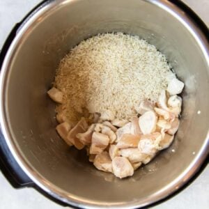 uncooked cubed chicken and rice in a pressure cooker