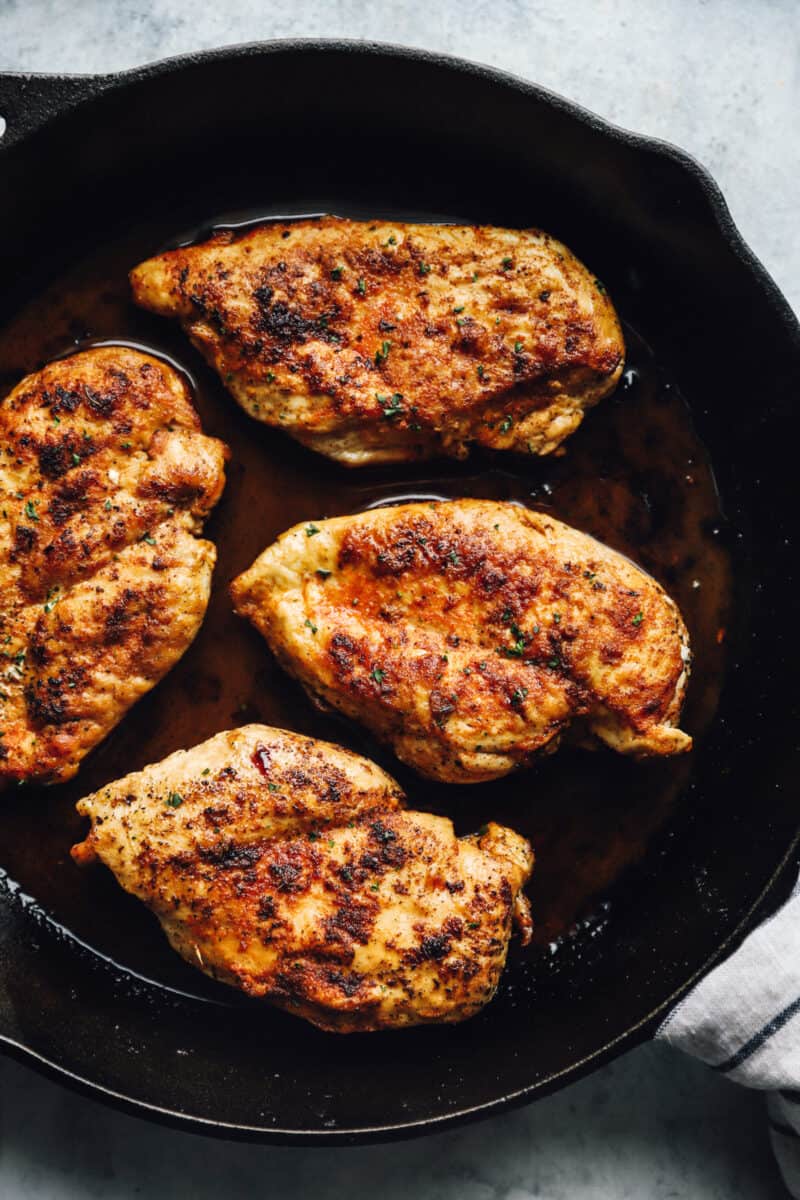 chicken breasts cooking in a pan