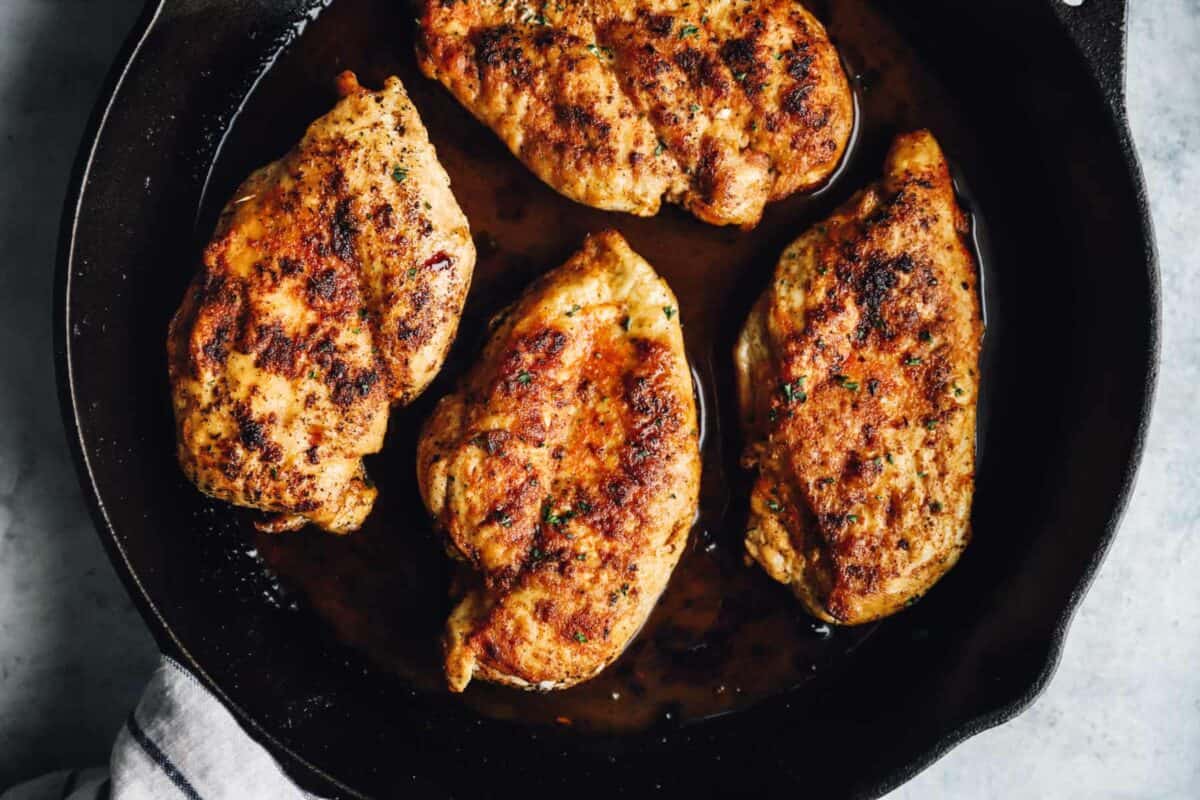 chicken breasts cooking in a pan