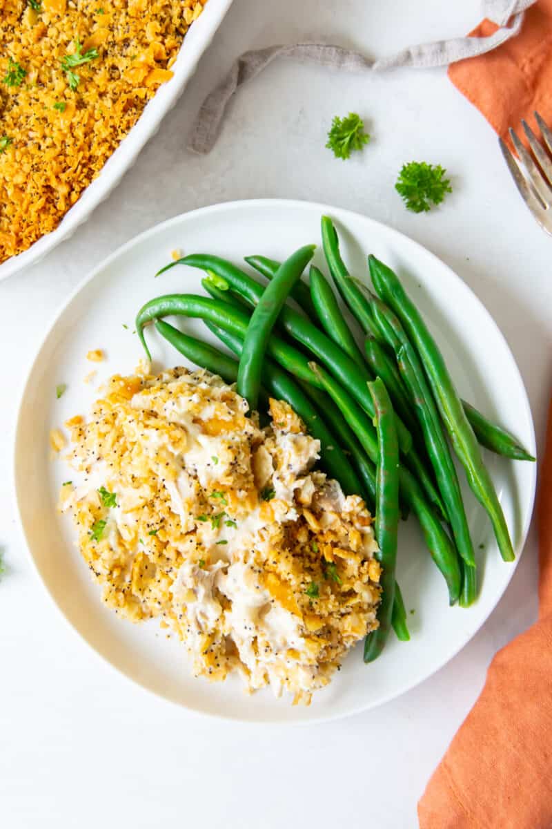 chicken poppyseed casserole served on a plate with green beans