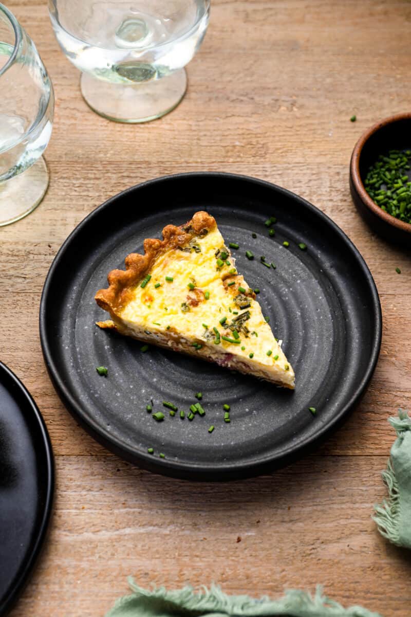 plate of quiche Lorraine at the center of a tablescape