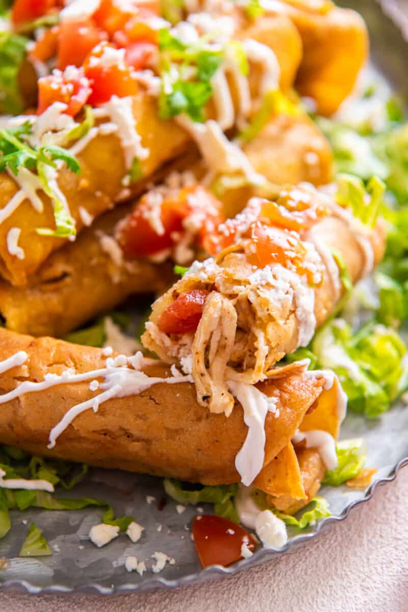close up on chicken taquitos on a platter