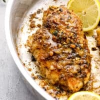garlic butter chicken breast and lemon slices in a skillet