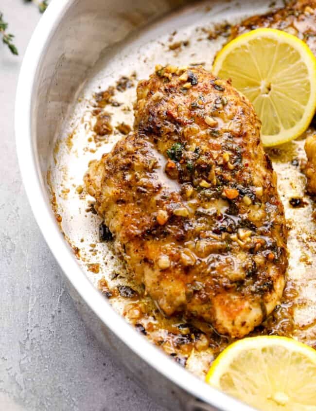 garlic butter chicken breast and lemon slices in a skillet