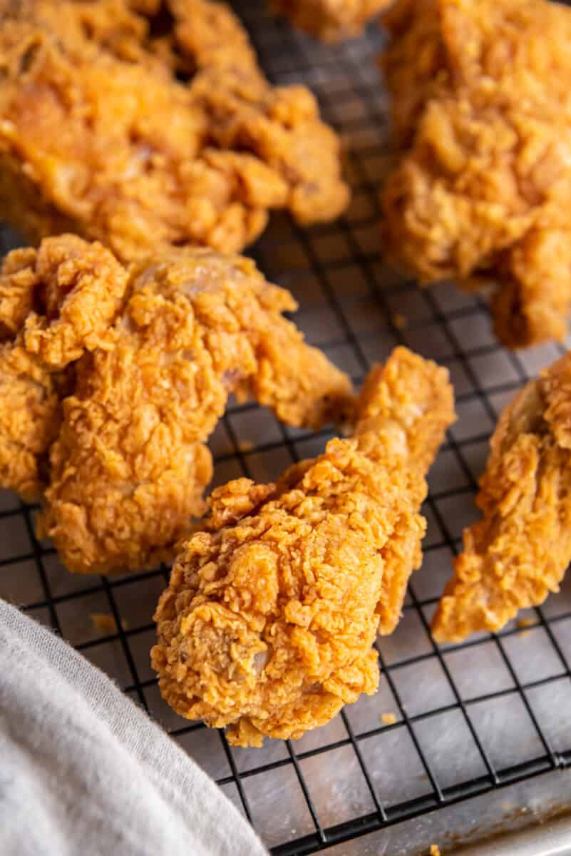 kentucky fried chicken drumsticks and other pieces on a cooling rack