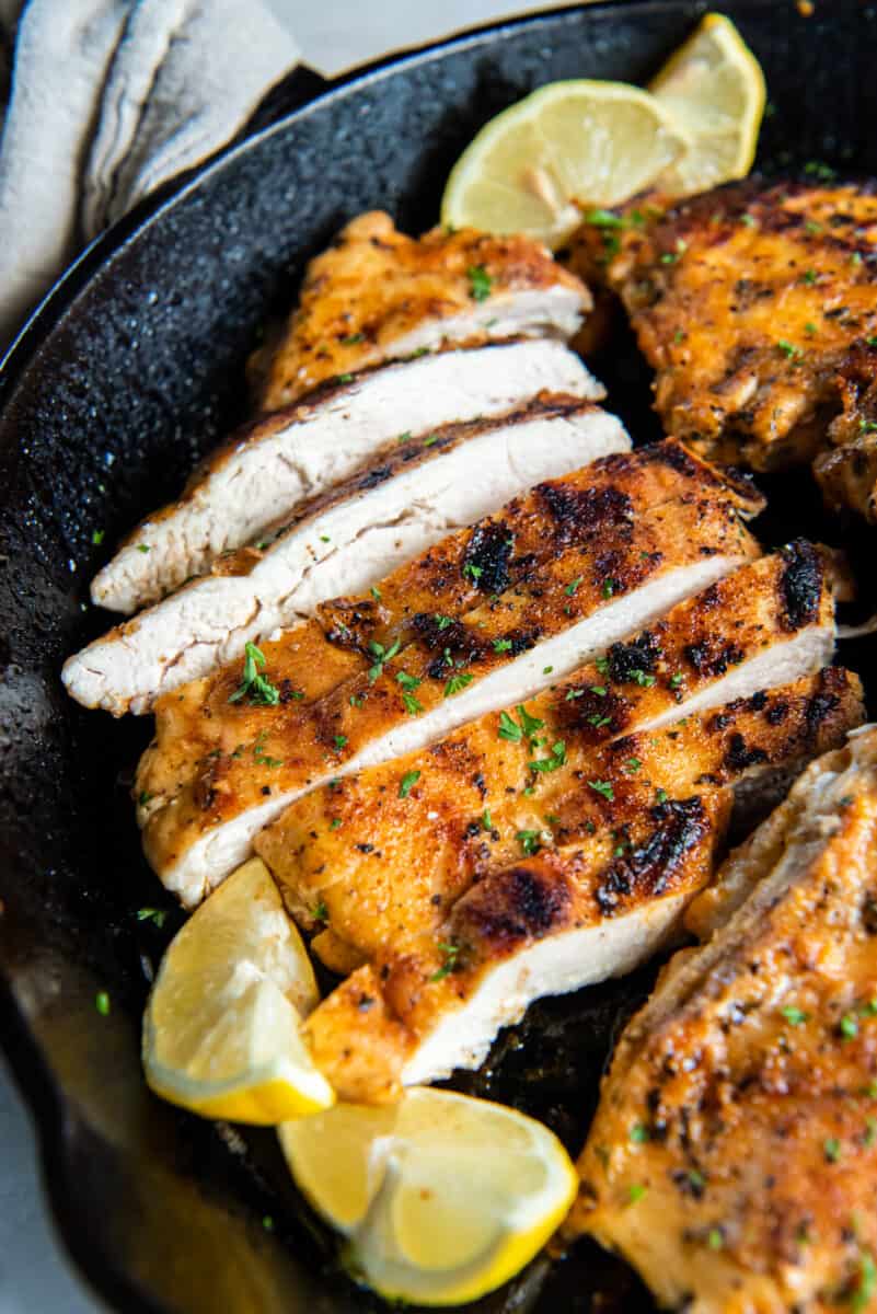 close up on pan fried chicken breasts, thinly sliced