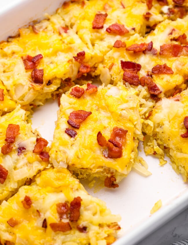 close up on breakfast casserole sliced into squares in a casserole dish