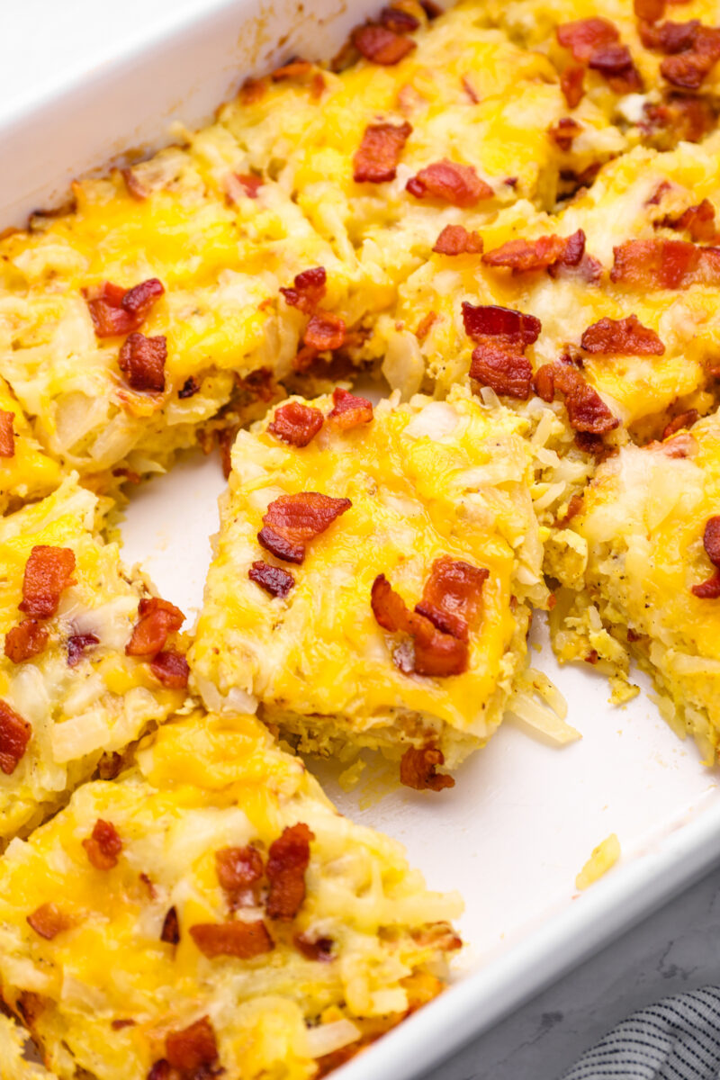 close up on breakfast casserole sliced into squares in a casserole dish