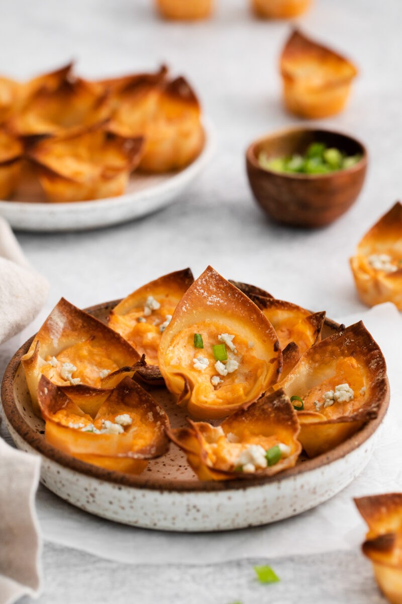 buffalo chicken wonton cups on a white and brown plate.