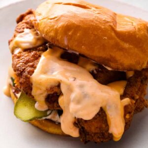 copycat Popeyes chicken sandwich with sauce on a plate