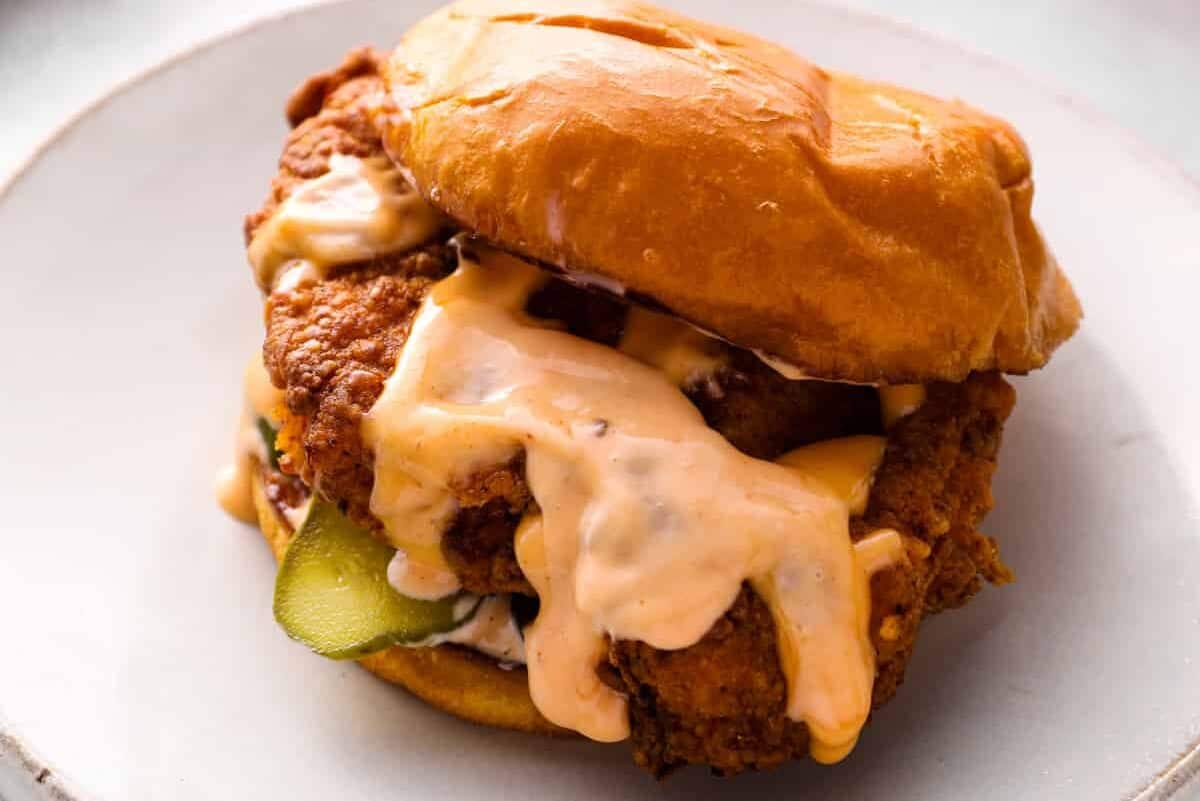 copycat Popeyes chicken sandwich with sauce on a plate.