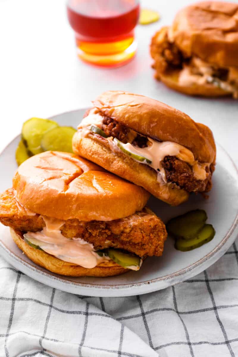 two Popeyes chicken sandwiches on a plate with pickles