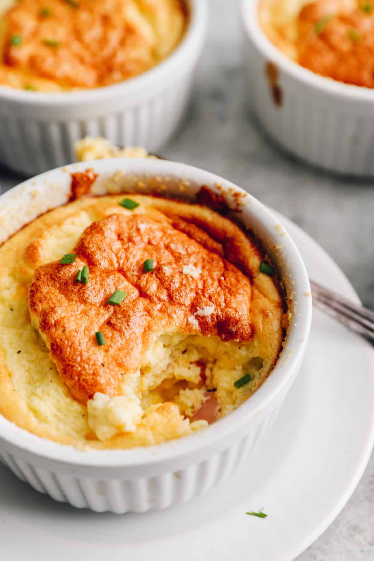 close up on a ham and cheese breakfast souffle in a white ramekin