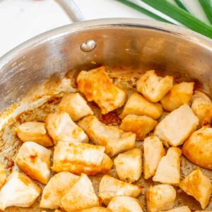 cooked diced chicken in a frying pan.