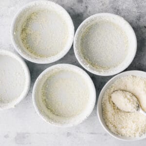 four white bowls filled with flour and a spoon, perfect for making a breakfast souffle.