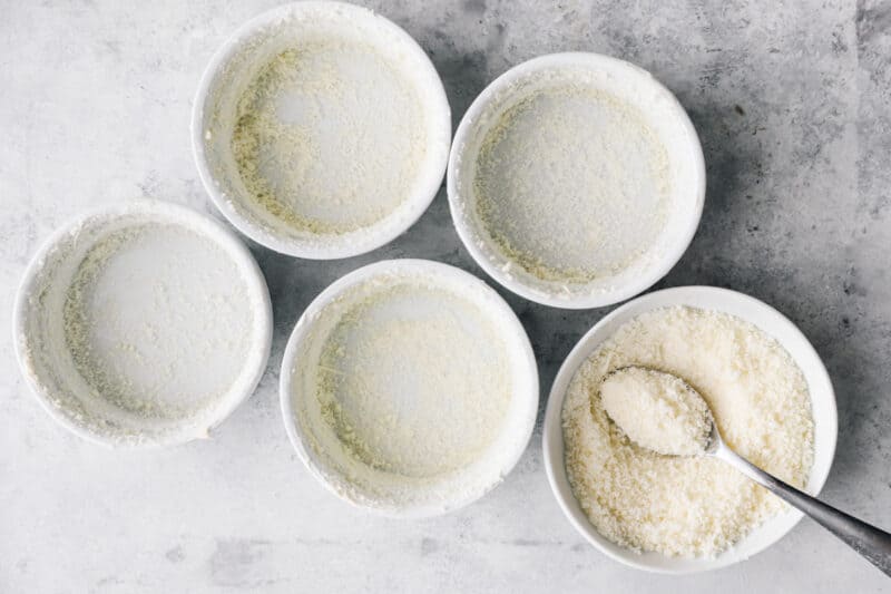 four white bowls filled with flour and a spoon, perfect for making a breakfast souffle.