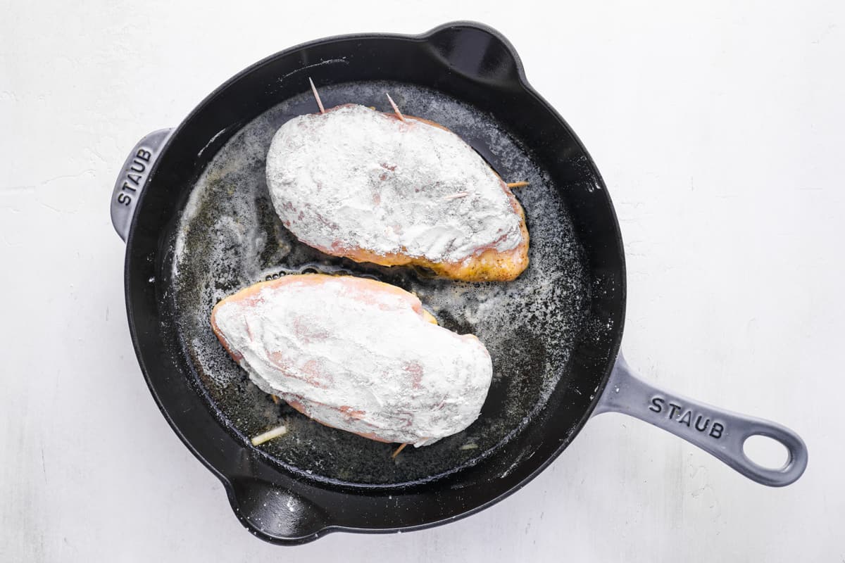 chicken breasts pan-frying in a skillet.
