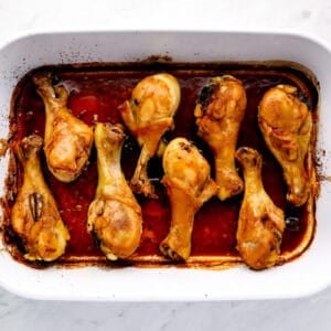 chicken drumsticks lined up in a baking dish