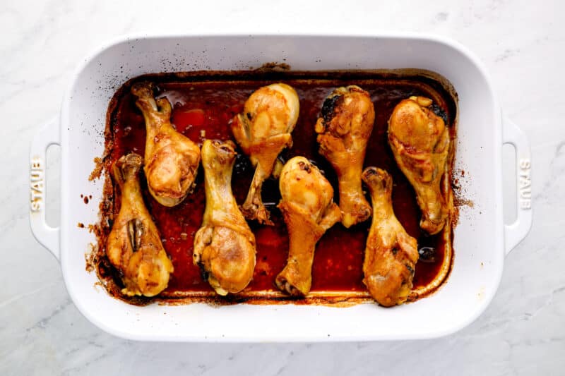 chicken drumsticks lined up in a baking dish