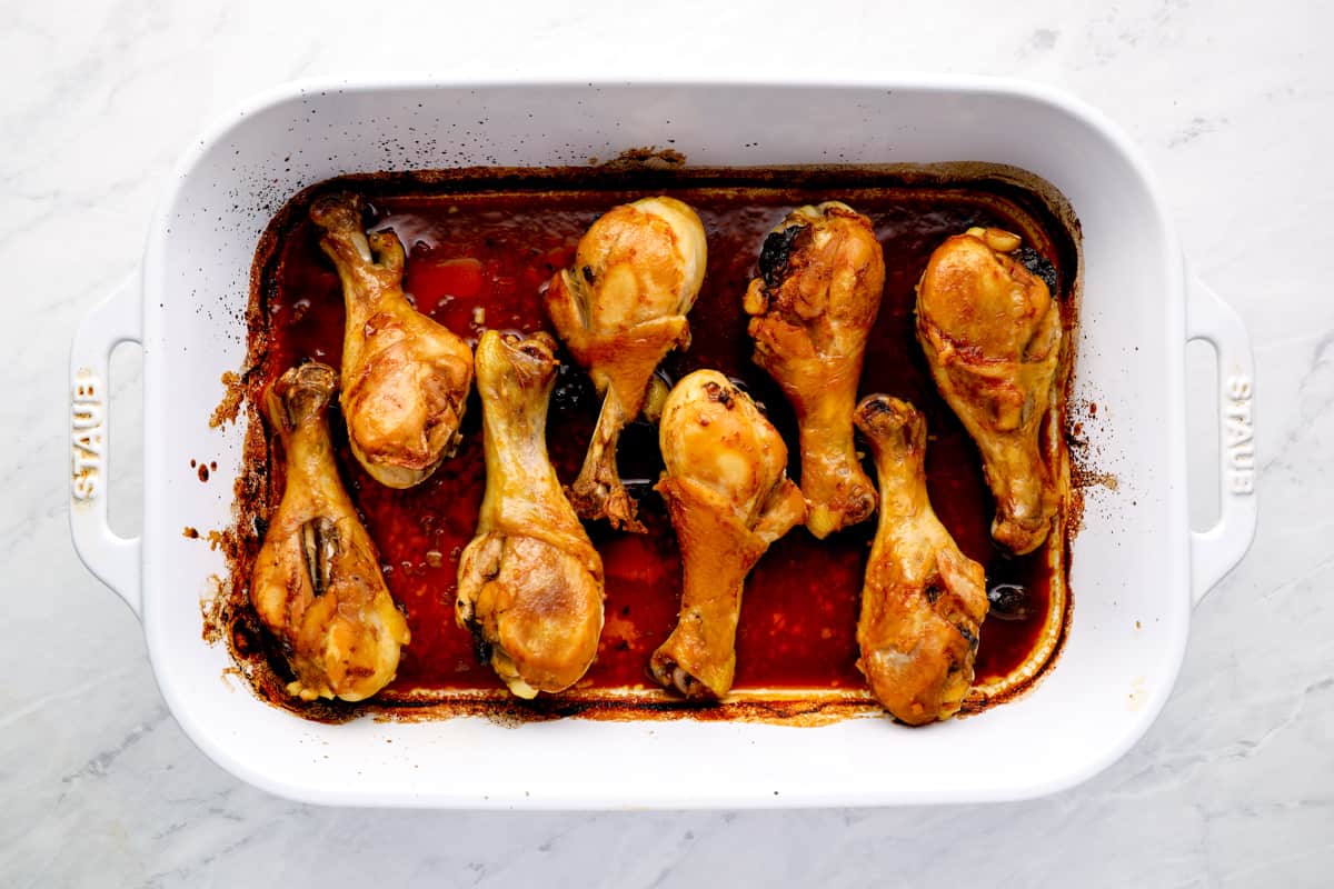 chicken drumsticks lined up in a baking dish.