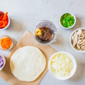 Chicken quesadilla ingredients and Thai chicken pizza laid out on a table.