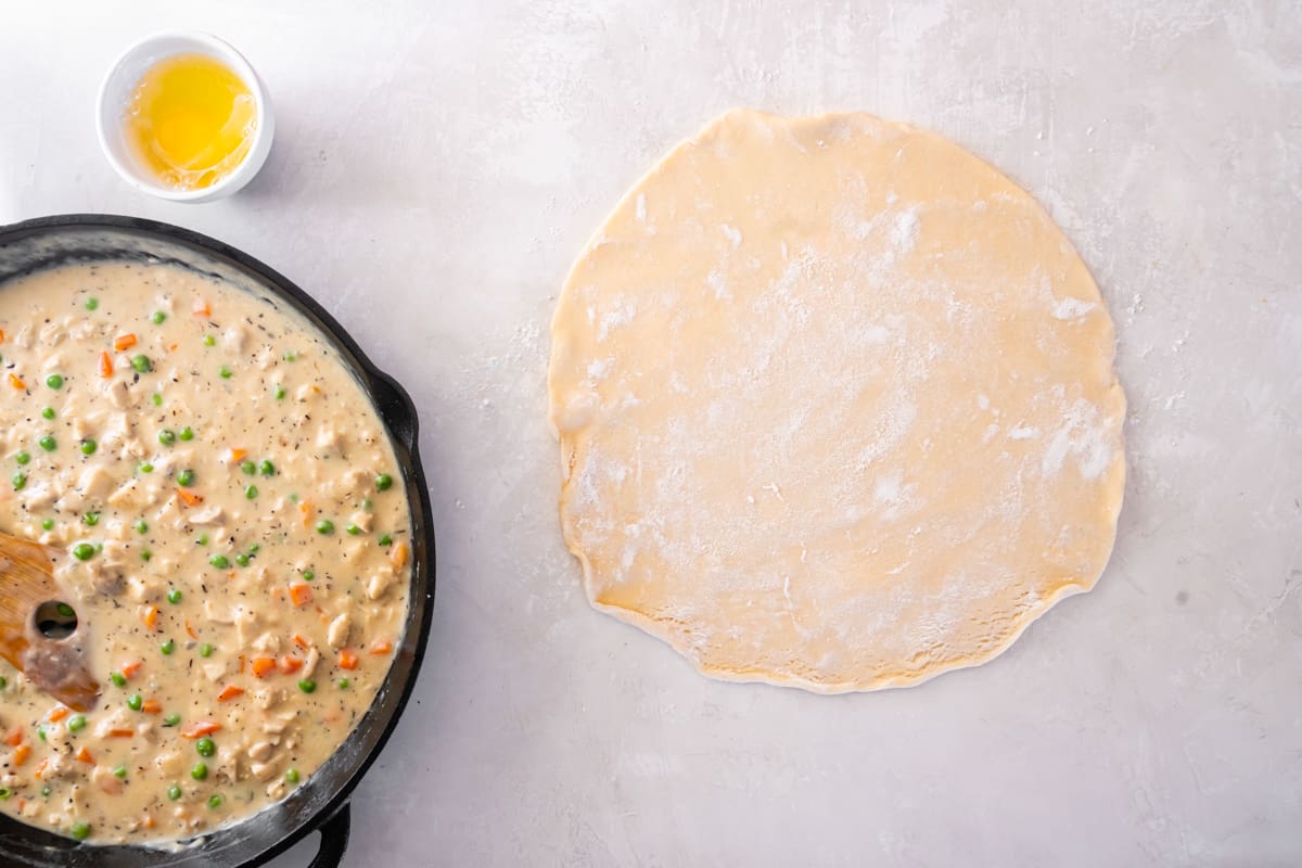 A rolled out disc of pie dough on a countertop.