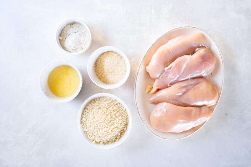 overhead view of ingredients for parmesan ranch chicken in individual bowls.