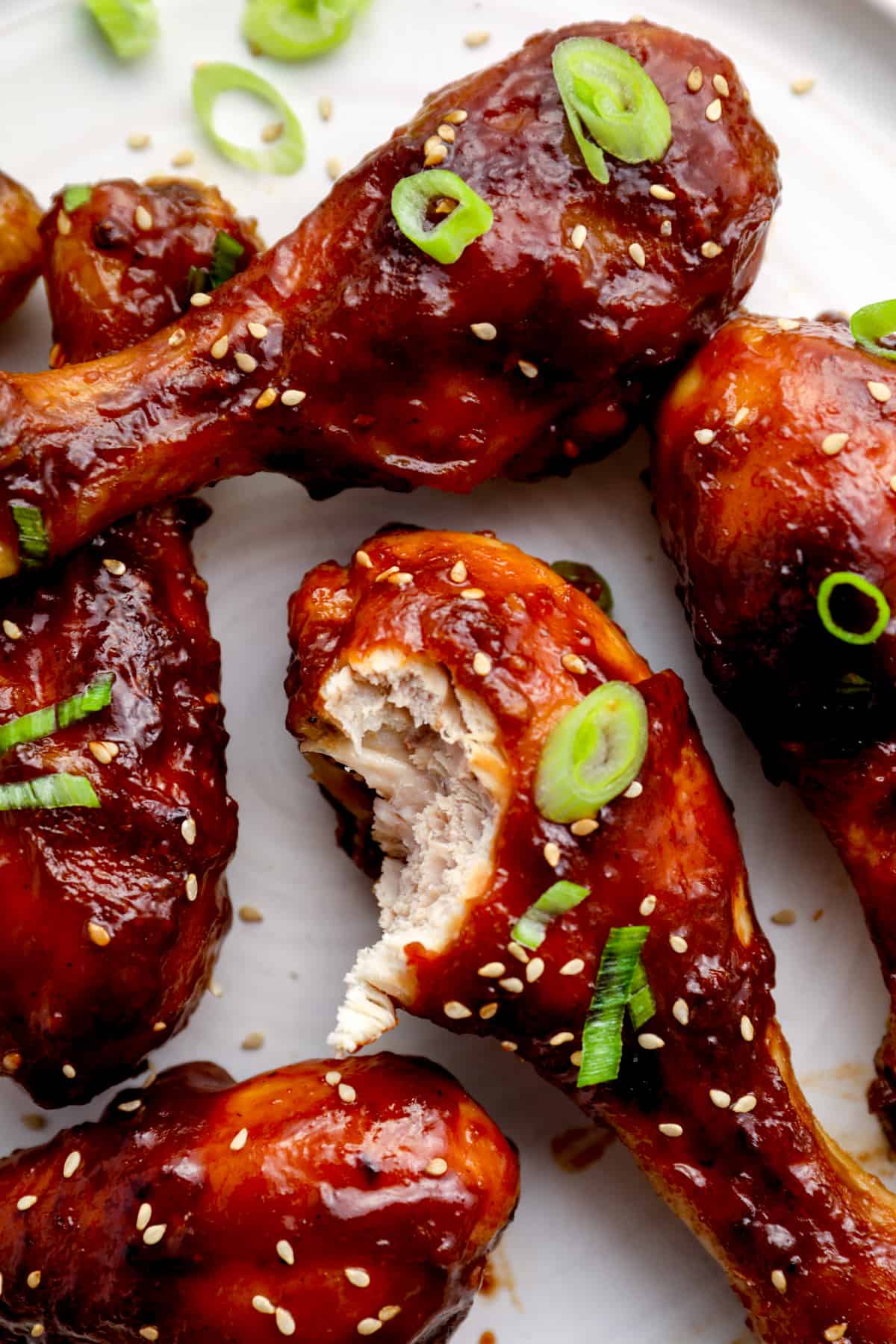 baked teriyaki chicken drumsticks, one has a bite taken out