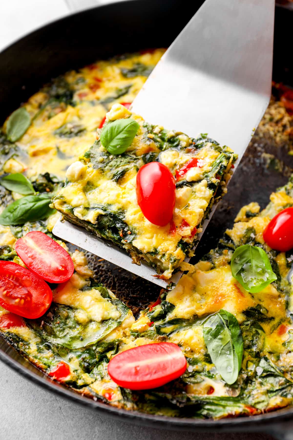 spatula scooping up a piece of frittata out of a skillet