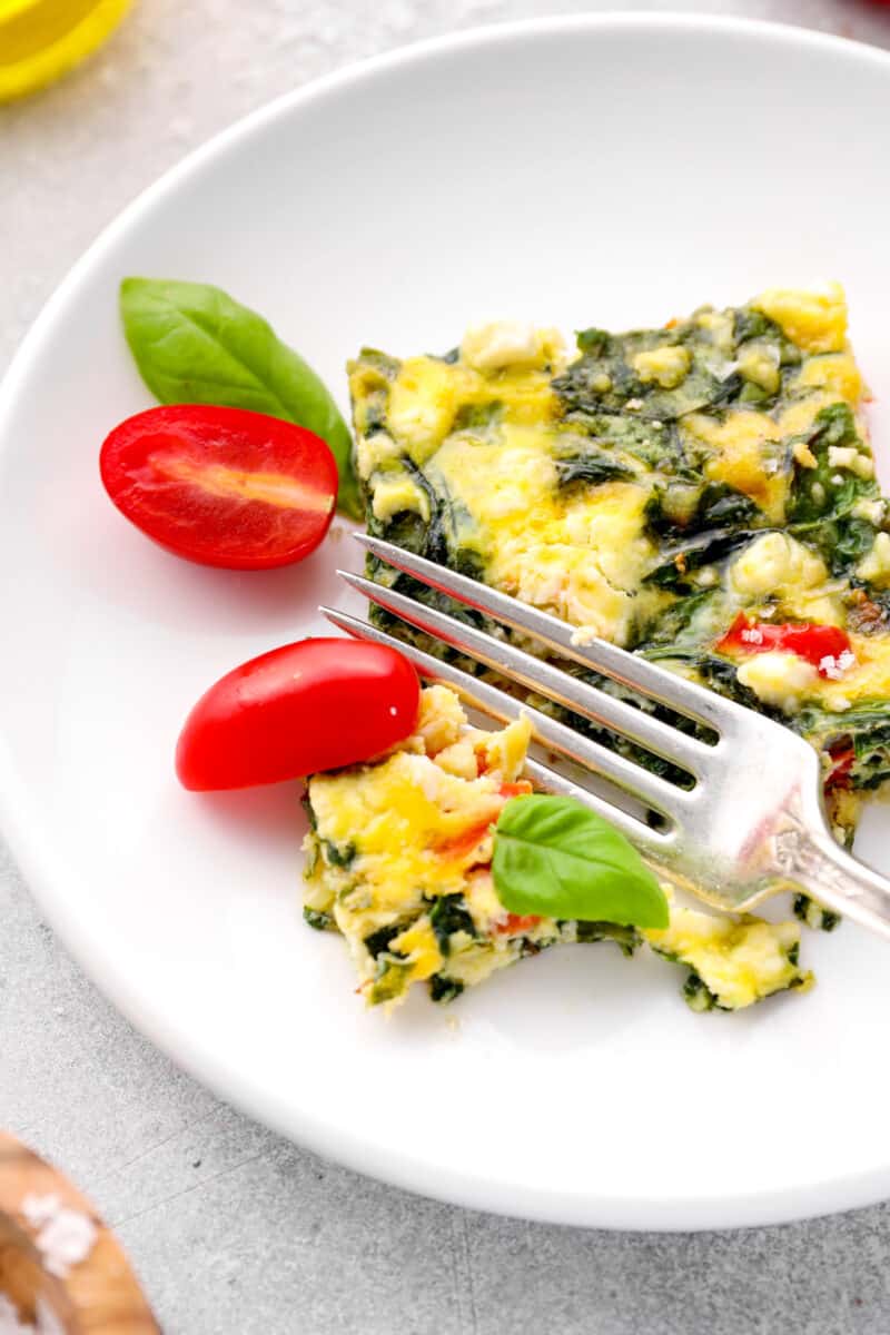 fork slicing into a piece of vegetable frittata