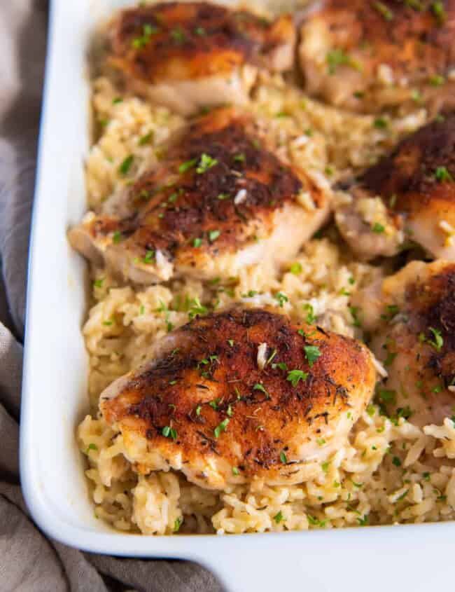 three-quarters view of baked chicken and rice in a casserole dish.