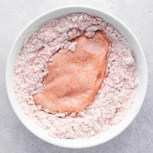 dredging chicken breast in seasoned flour