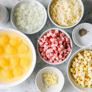 overhead view of ingredients for ham and cheese frittata in individual bowls.