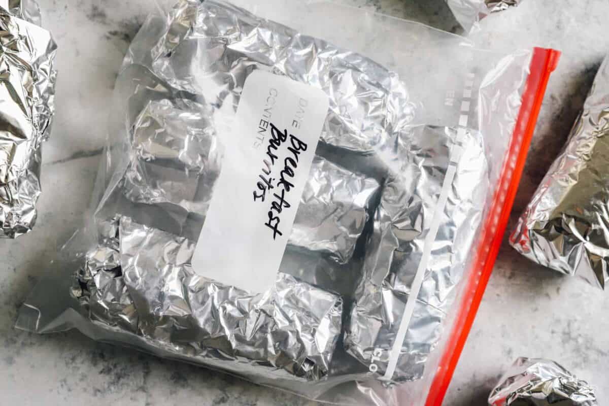 breakfast burritos wrapped in foil and inside of a freezer bag