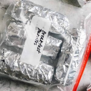 breakfast burritos wrapped in foil and inside of a freezer bag