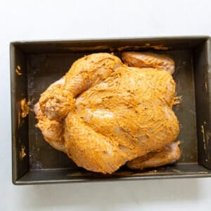 A baking pan with a rotisserie chicken.