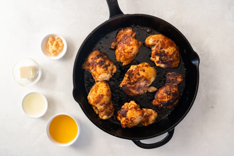 chicken thighs cooking in a skillet