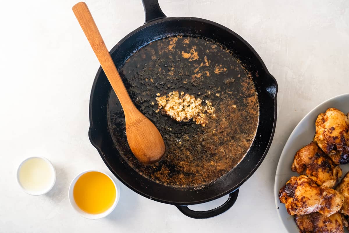 Garlic cooking in a skillet with butter.