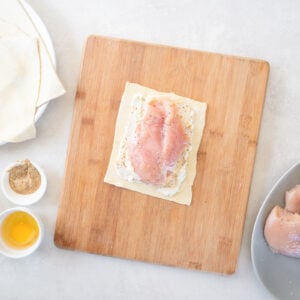uncooked chicken breast centered on a piece of pastry dough
