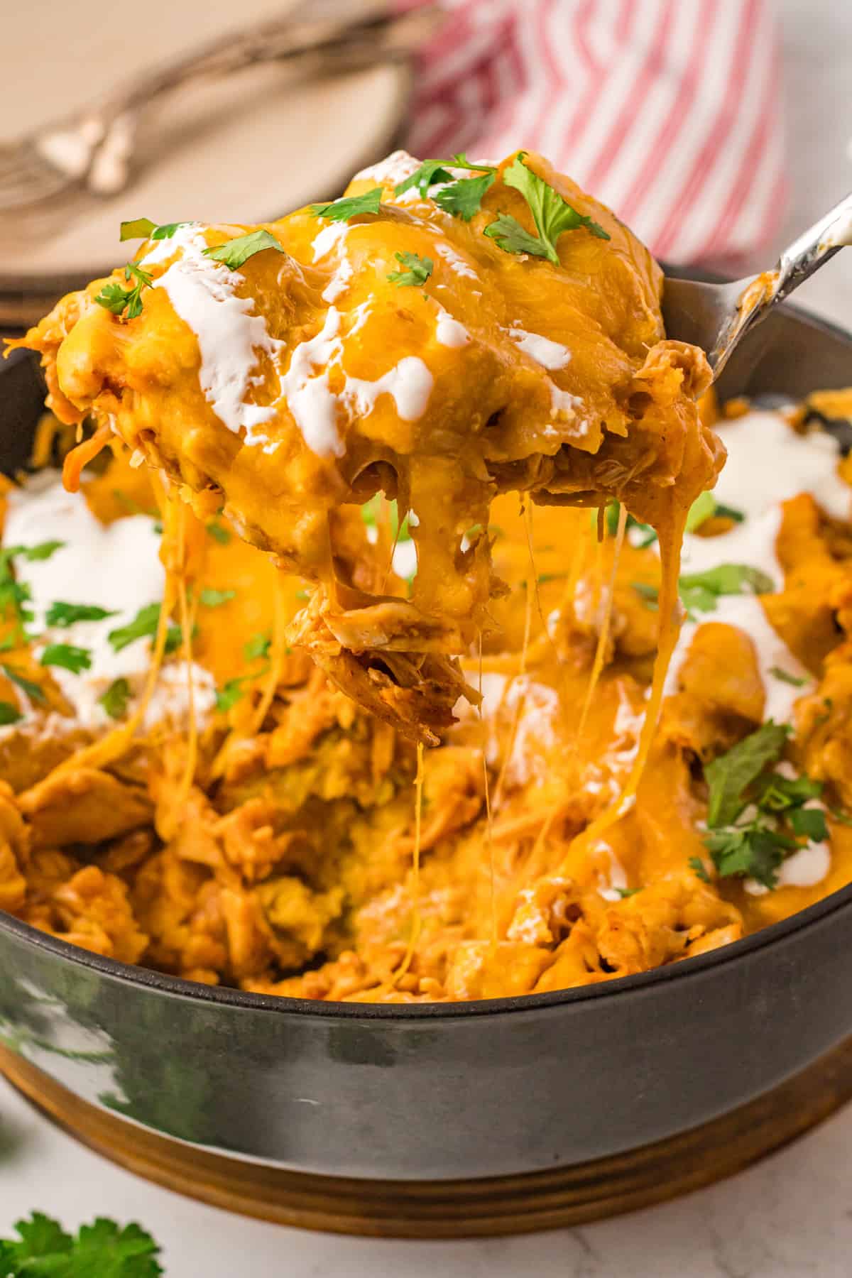 serving spoon lifting up a piece of cheesy chicken tamale pie.