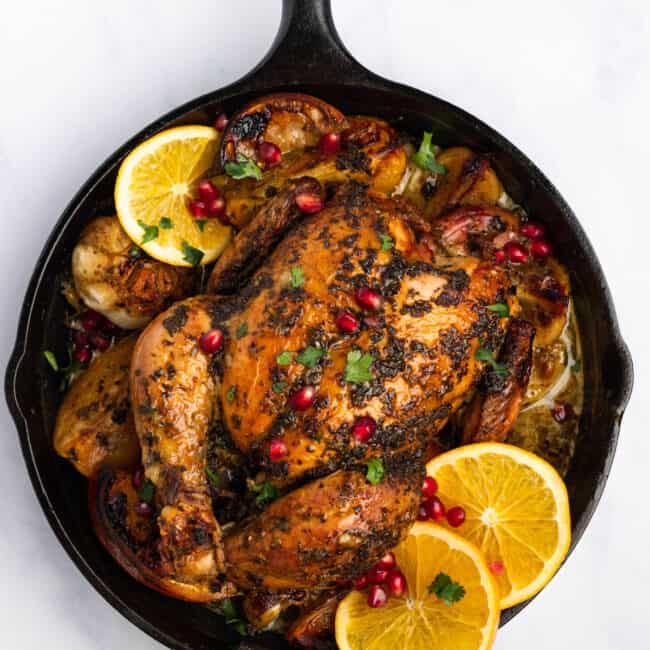 overhead view of christmas chicken in a cast iron skillet.