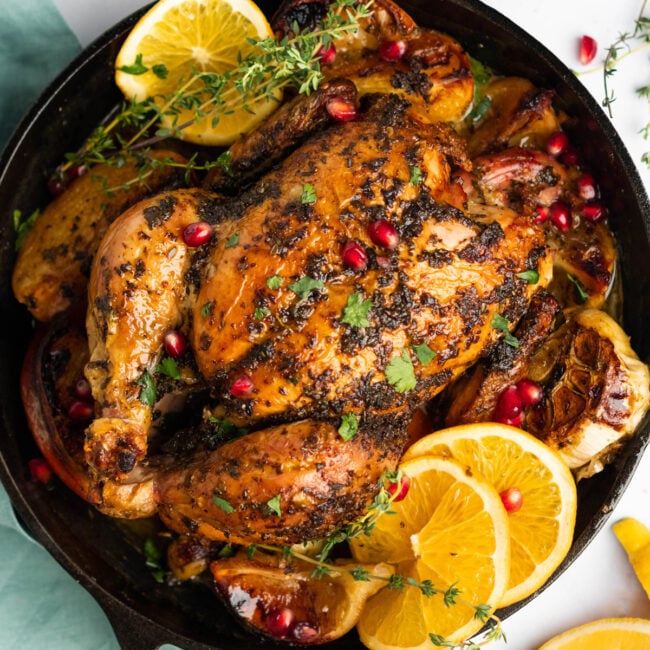 overhead view of christmas chicken in a cast iron skillet.