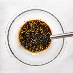 balsamic marinade in a glass bowl with a whisk.
