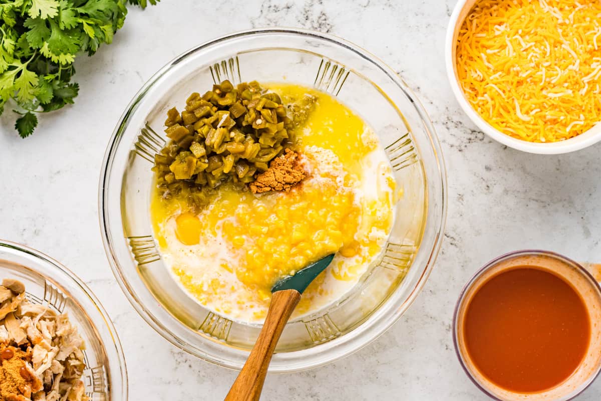 Combining cornbread ingredients in a mixing bowl.