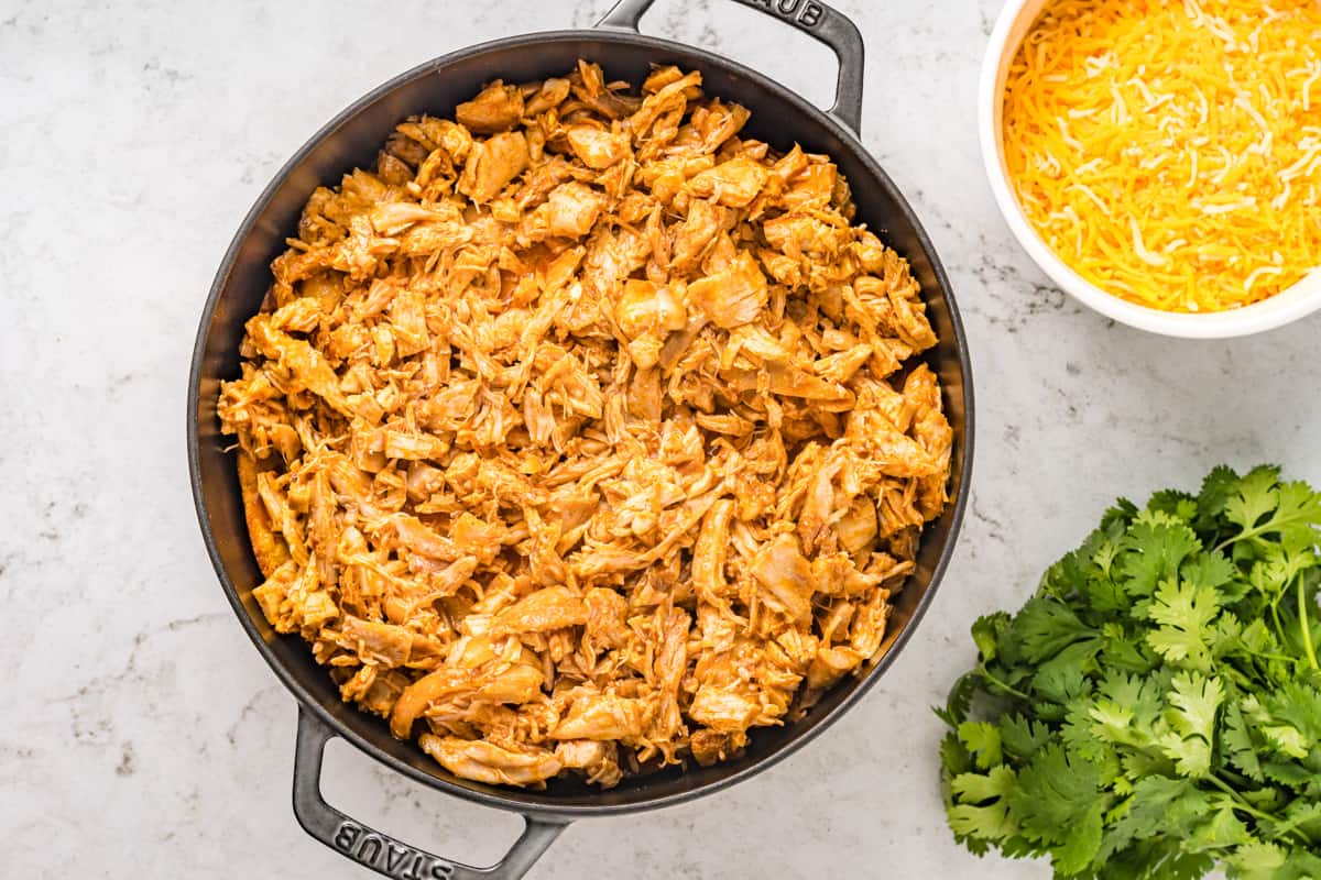 A layer of shredded chicken on top of a casserole.