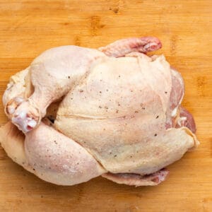 a whole chicken on a cutting board.