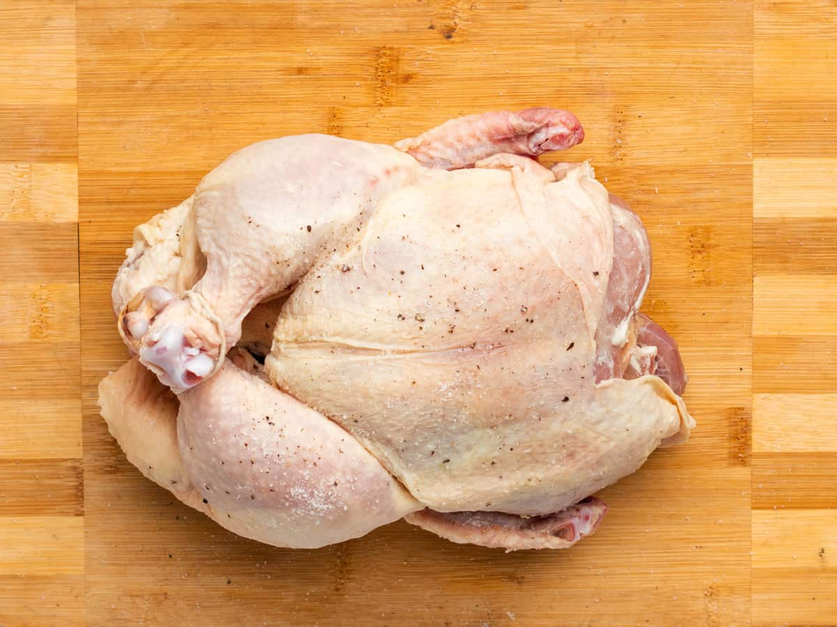 a whole chicken on a cutting board.