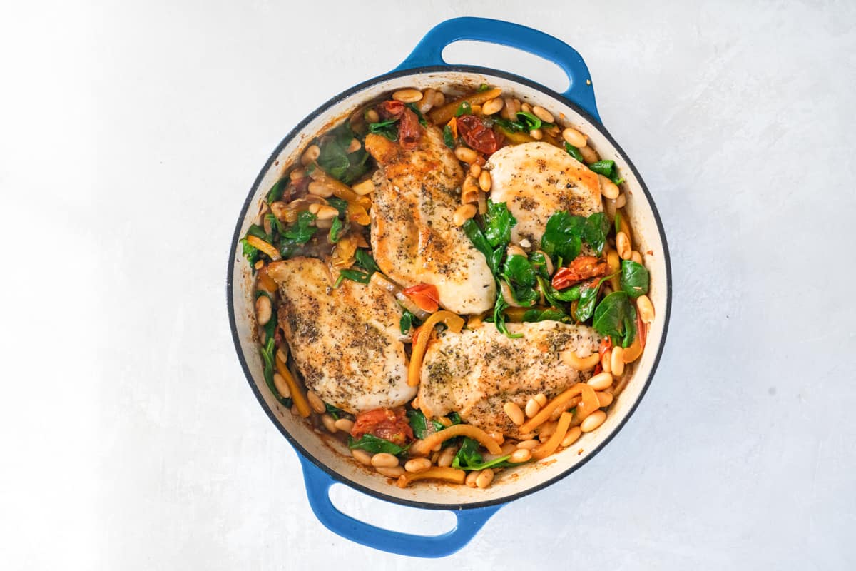 4 chicken breasts nestled into italian chicken skillet in a cast iron pan.