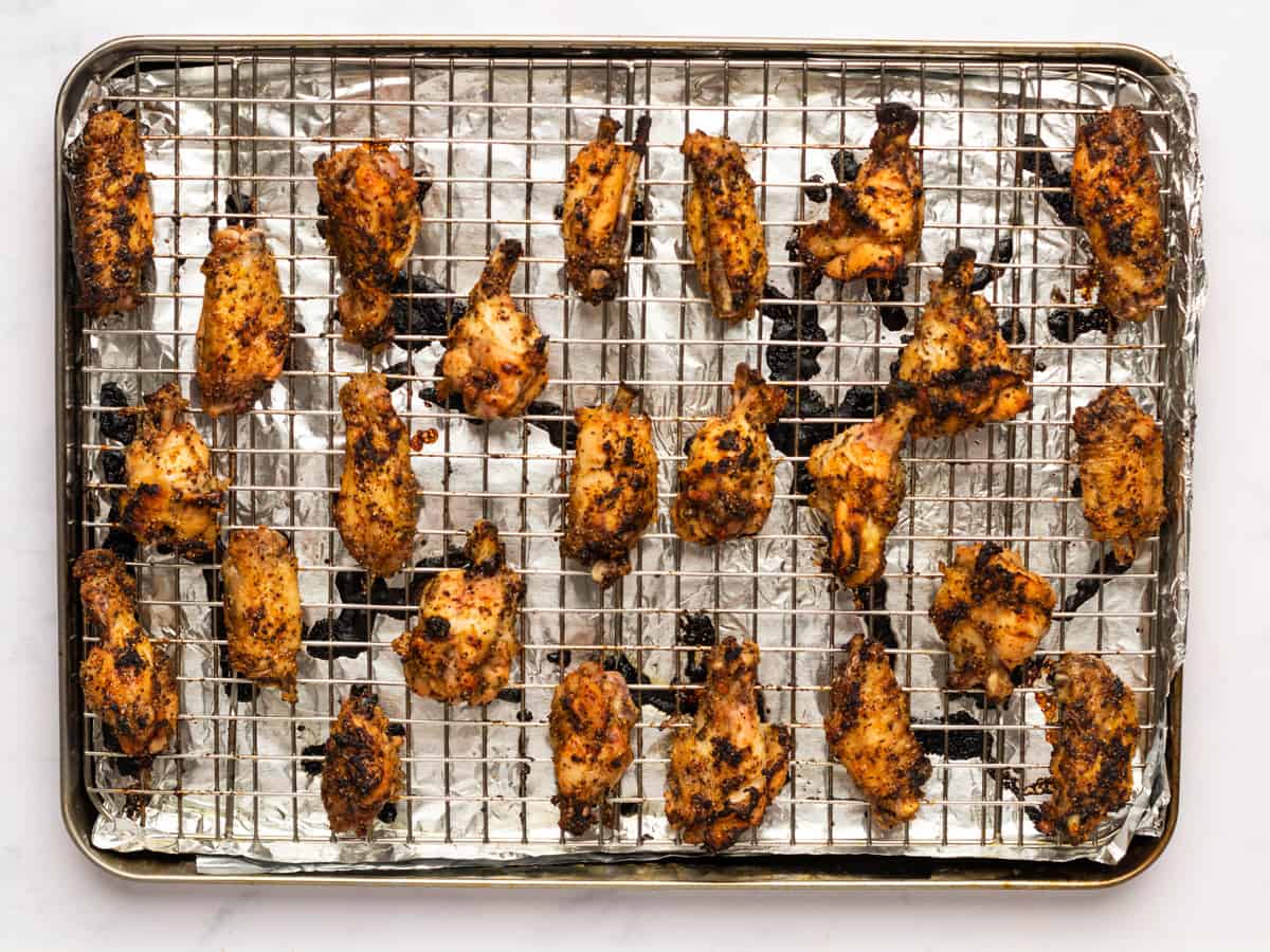 baked lemon pepper wings on a wire rack set in a baking sheet.