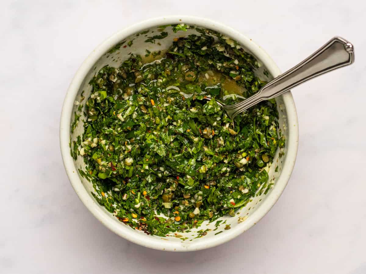 gremolata in a white bowl with a spoon.